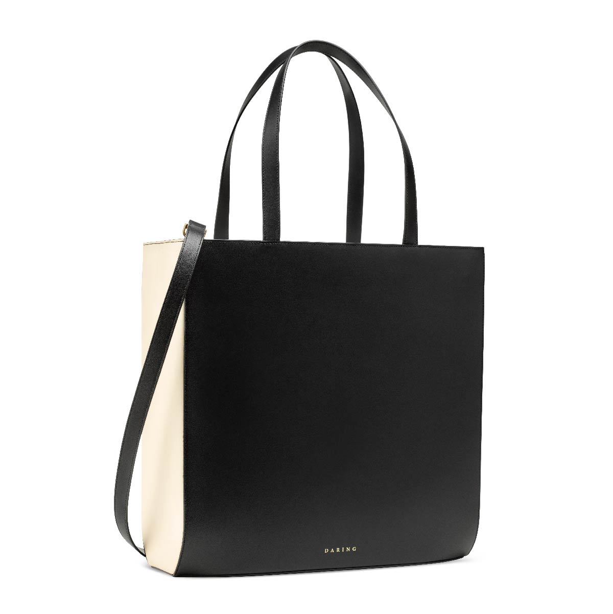 The Tote in Black + Cream, with removable strap and top handles, three quarter view.