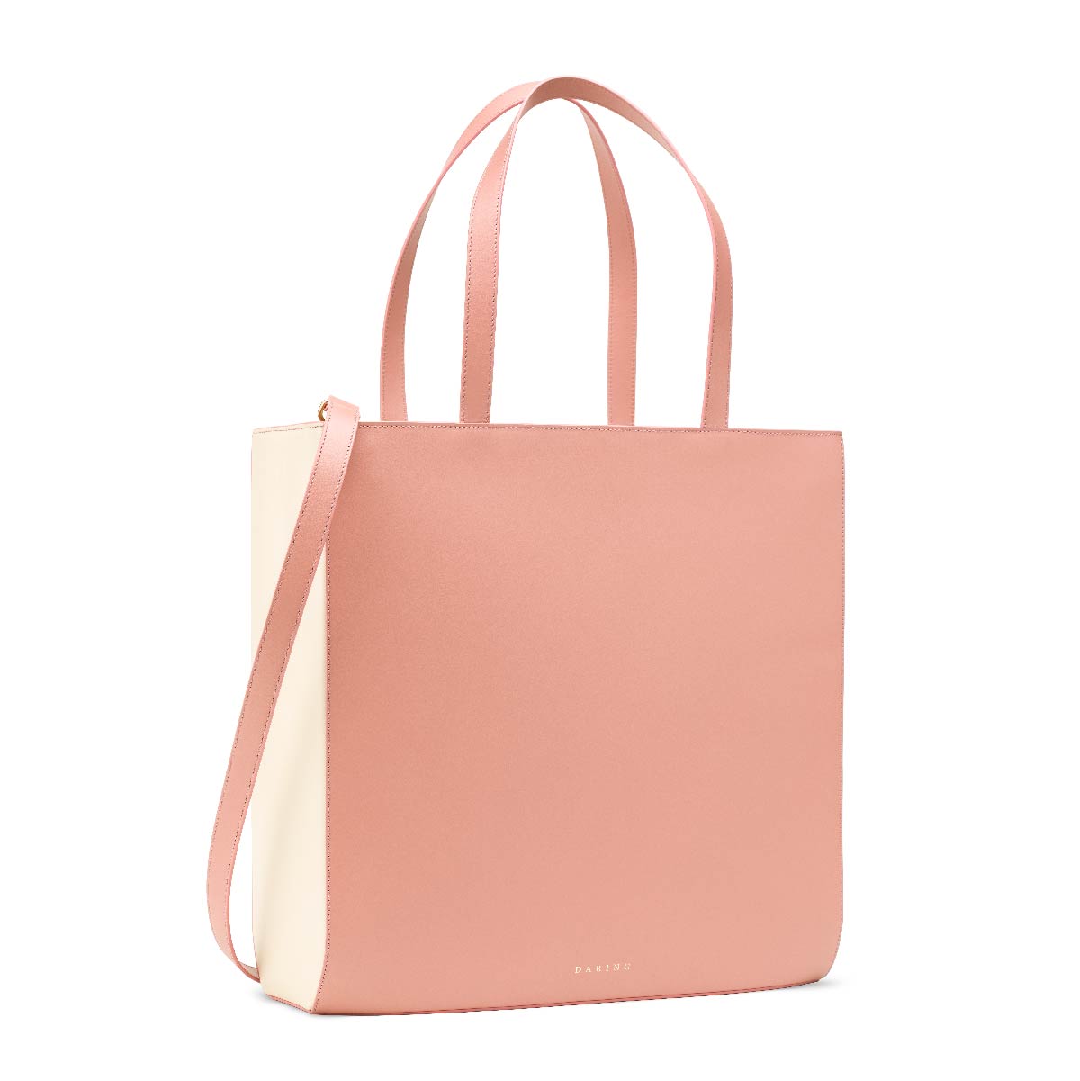The Tote in Pink + Cream, with removable strap and top handles, three quarter view.